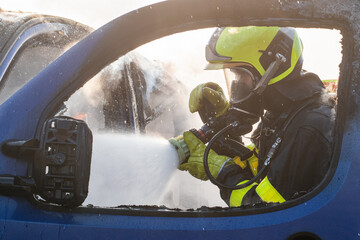 Detail of a firefighter with breathing apparatus when extinguishing a car fire
