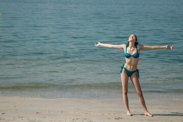 happy free young woman posing in bikini on the beach