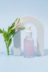 Cosmetic bottle with body and face oil with alstromeria flower in the arch, summer natural cosmetics, serum, facial oil, tropical concept