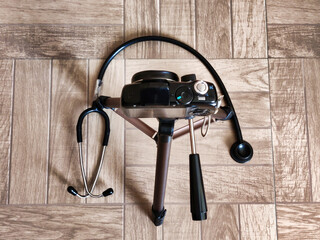 Picture of a camera mounted on a tripod with a stethoscope lying on ground