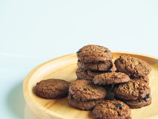 Delicious chocolate cookies on a wooden plate     