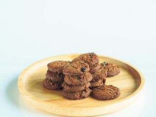 Delicious chocolate cookies on a wooden plate     