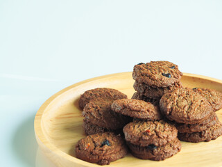 Delicious chocolate cookies on a wooden plate     
