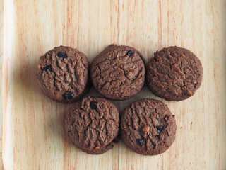Delicious chocolate cookies on a wooden plate     