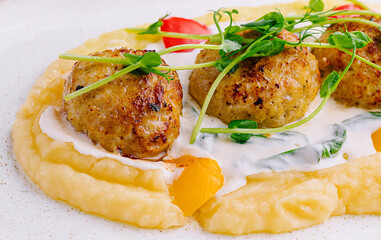 Meatballs with mashed potatoes on white plate