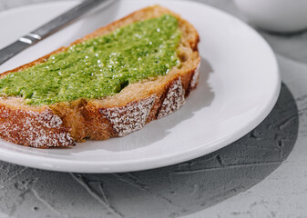 bread with homemade pesto sauce spread with a knife