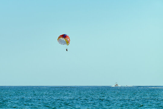 Couple is parasailing in the blue sky. Summer vacation on the Black Sea.