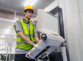Young adult engineer operating automated CNC machine at futuristic research development factory. Electrician technician working with skill on accurate precision process machinery in lathe or cut steel