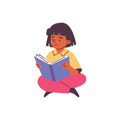 A dark-skinned girl reads a book while sitting on the floor.