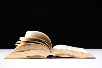 Pages of a thick book are turned on a white and black background, space for text.