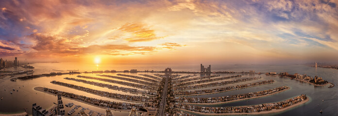 Beautiful, panoramic sunset view of The Palm island in Dubai, UAE, from the Marina to Jumeirah and downtown district on the horizon