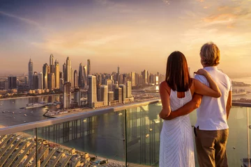 Fotobehang A hugging couple enjoys the panoramic sunset view of the Dubai Marina, UAE © moofushi