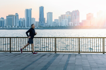 Man senior 50s jogging on promenade at sunrise. Active healthy lifestyle.
