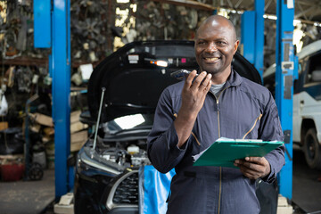 male worker talking on smartphone with customer in garage