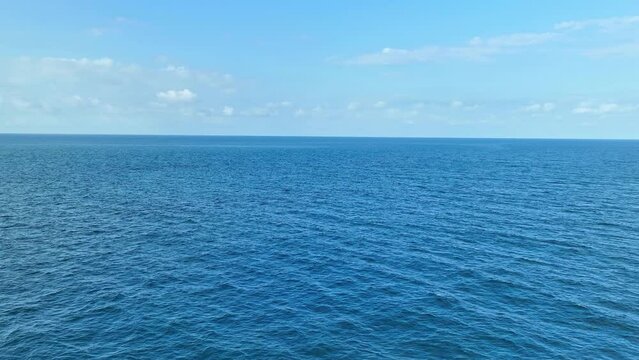 Explore the infinite beauty of the endless sea through the lens of a drone. Crystal-clear waters mingle with the azure sky, creating a breathtaking panorama. Stock footage. Tropical sea background. 
