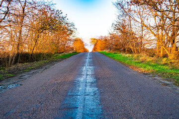 Fototapeta premium Beautiful empty asphalt road in countryside on colored background