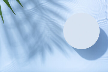 Empty podium or pedestal with water ripple and palm leaf shadow flat lay, top view. Summer cosmetic template, mock up