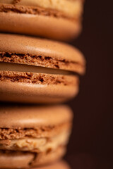 four brown coffee macaron on a brown background