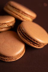 four brown coffee macaron on a brown background