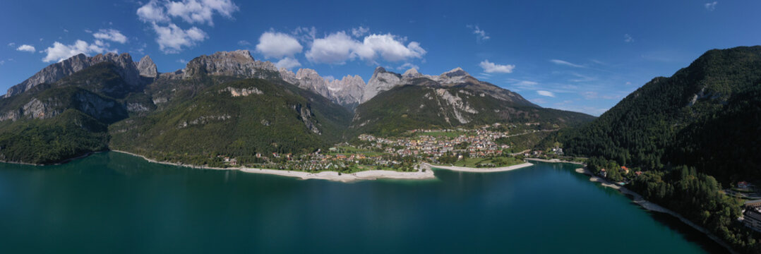 Aerial view of Lake Molveno, north of Italy in the background the city of Molveno, campanile basso, cima tosa Italian dolomites. Panoramic view of the Alpine Italian town of Molveno on the lake.
