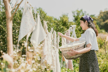 Rural farm girl folk women maid housewife drying clothes outdoors vintage retro style countryside...