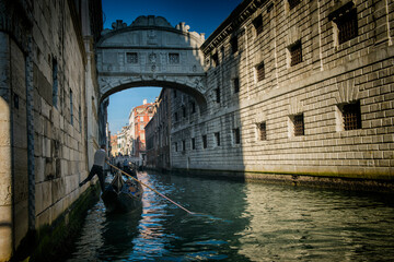 Narrow canals with bridge of Venice, Italy. Tourist sailing on an romantic gondola with gondolier boat. Exterior of medieval buildings. - obrazy, fototapety, plakaty