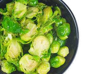 Cooked organic brussels sprouts in glass bowl isolated on white background.Top view