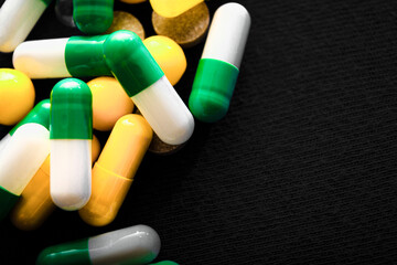 Medical pills. Color capsules medication. Black background. Health care concept. Free space for text. Medicines. Many different pills. Chemical industry.
