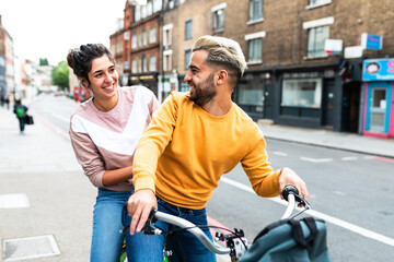 Happy caucasian couple riding a bike in London