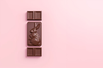 tablette de chocolat au lait de P&acirc;ques, avec un gros carr&eacute; emboss&eacute; d'un joli lapin de P&acirc;ques. sur fond rose clair avec espace n&eacute;gatif pour texte copyspace 