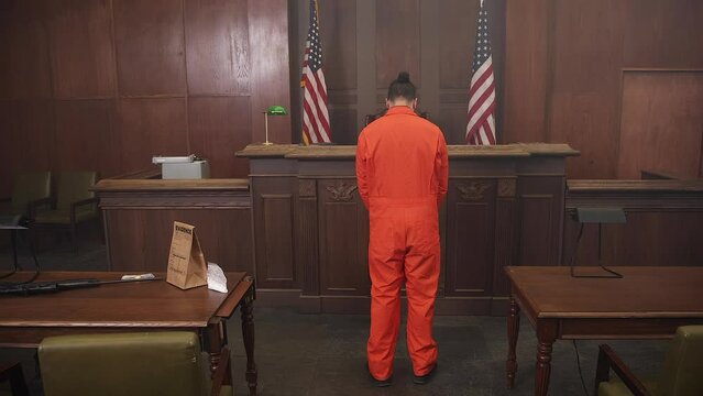 Inmate in court room bowing head in shame steve