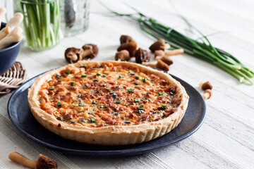 Quiche - open tart pie with spring morel mushrooms, onion and cheese on a plate