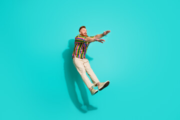 Full body size photo of jumping trampoline man arms up addicted shopaholic doing sportive exercises isolated on cyan color background