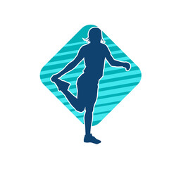 Silhouette of a slim sporty woman doing pilates exercise. Silhouette of a sporty female doing physical exercise. 