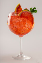 Gin and tonic with pink tonic, grapefruit and basil, front view.