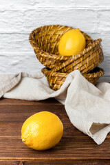 Lemons in basket on wooden table.