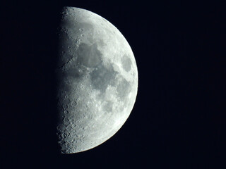 moon in the waxing half moon phase with clouds