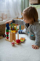 Toddler playing with toys on floor at home. Children learning in game. Domestic room, everyday life