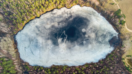 Aerial view of the lake in Lithuanian forests, winter, wild nature. Name of the lake "Kaniuku", Varena district, Europe.