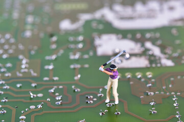 Photography of miniature people and toy figures, golfers on an electronic circuit board
​