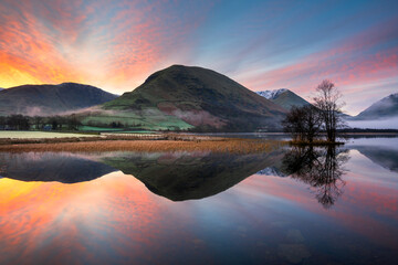 Beautiful sunrise with reflections in lake at Brothers Water on a calm morning in The Lake...