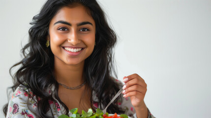 Portrait of a smiling 25+ indian woman enjoying a salad
