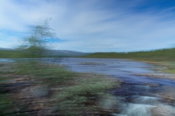 Intentional camera movement (ICM) of start of Siilaskoski rapids from lake Siilasjärvi in autumn, Kilpijärvi, Enontekiö, Lapland, Finland.