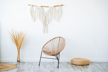 Wooden wicker chair against white wall in room with hardwood flooring