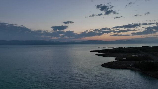 Scenic sunset or sunrise over Sevan lake popular holiday destination in Armenia, Caucasus, West Asia. Daytime Timelapse of moving white, grey clouds over lake Sevan on background hills