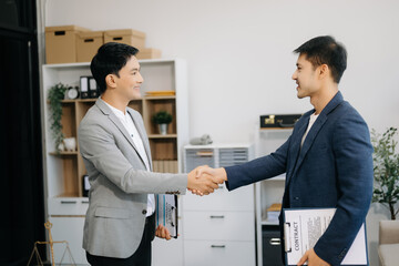 Asian Man lawyer hand and Humen client shaking hand collaborate on working agreements with contract...