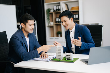 balancing the property sector The real estate agent is explaining the house style to see the house design and the purchase agreement. model house