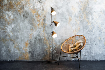 A wooden chair and a metal lamp illuminate the room