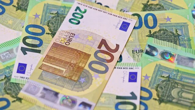 One and two hundred euro banknotes in slow rotation as background