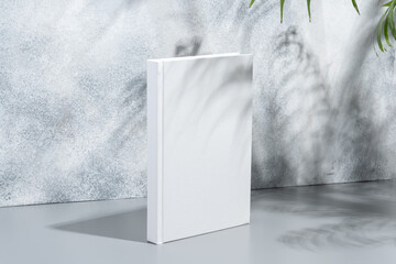 White blank book with hard cover on gray background with shadows